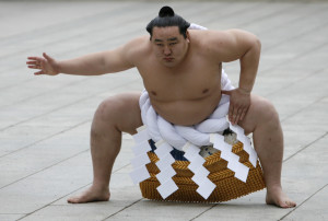 Mongolian-born grand sumo champion Yokozuna Asashoryu wears a ceremonial belly band as he performs a ring-entering ritual at Meiji Shrine in Tokyo January 7, 2008. Asashoryu was banned in August 2007 and fled to his homeland after he outraged fans when he was caught on video playing soccer while supposedly out of action with a back injury. REUTERS/Toru Hanai (JAPAN) - RTX5ATL